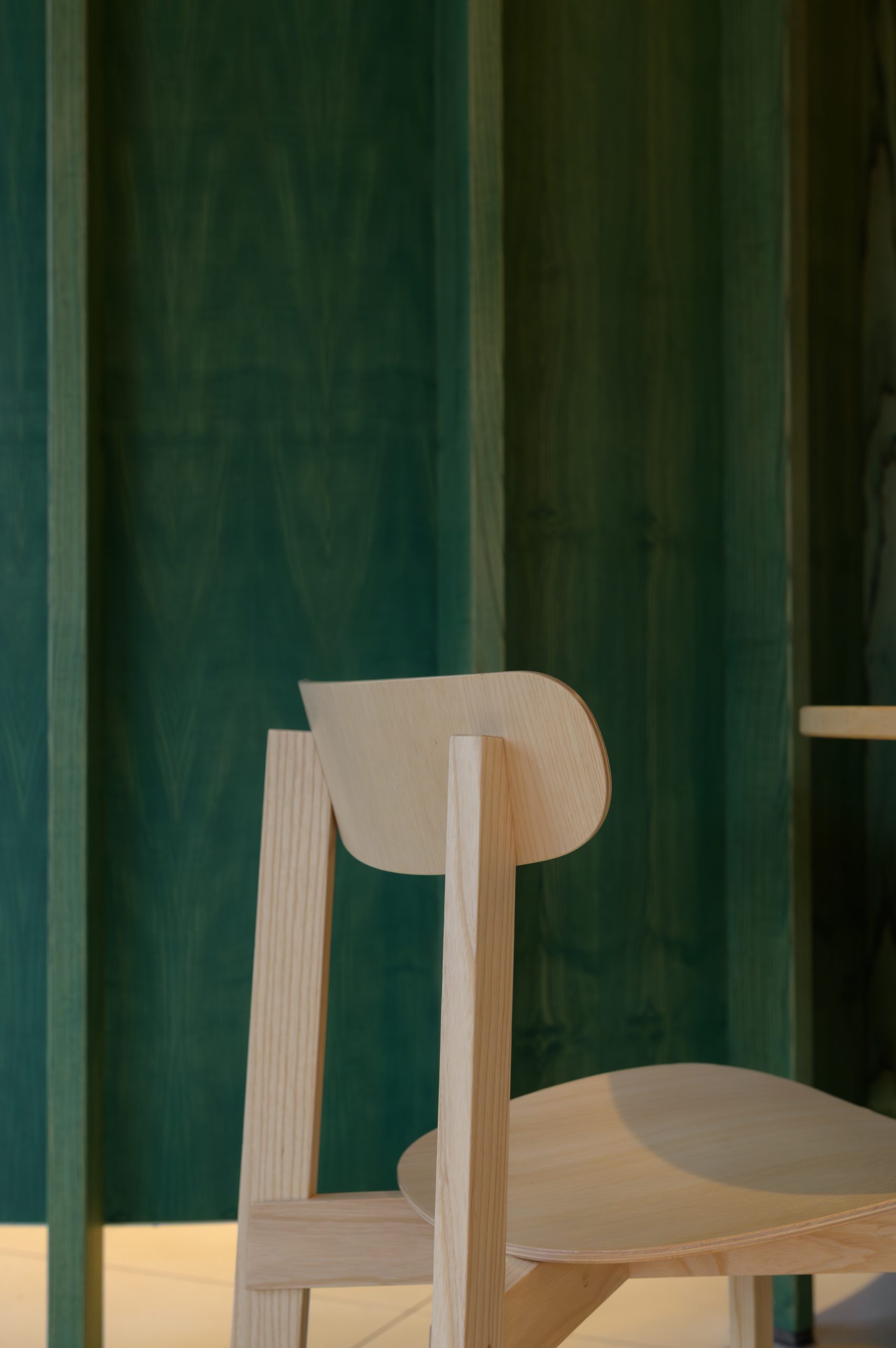 Stuhl vor grünem Raumtrenner